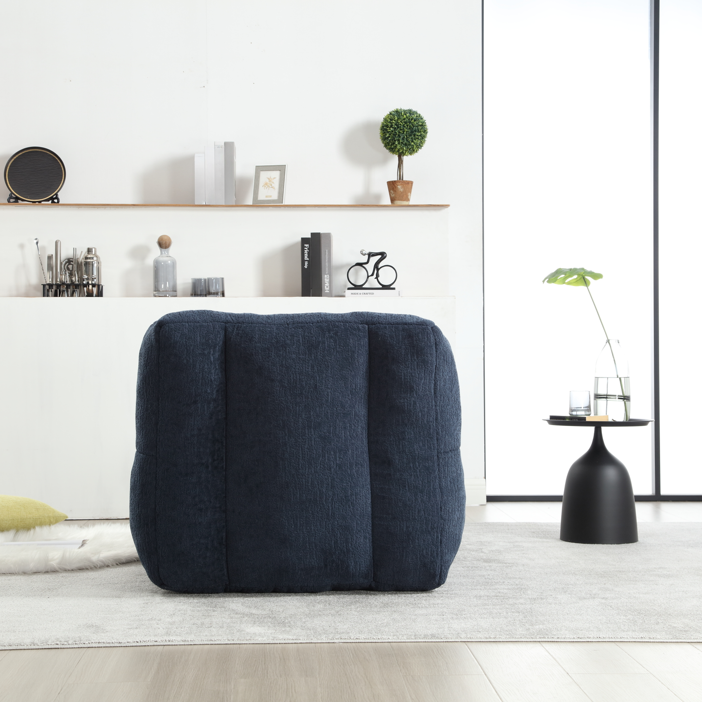 Navy blue textured fabric pouf ottoman with padded surface and stitched seams