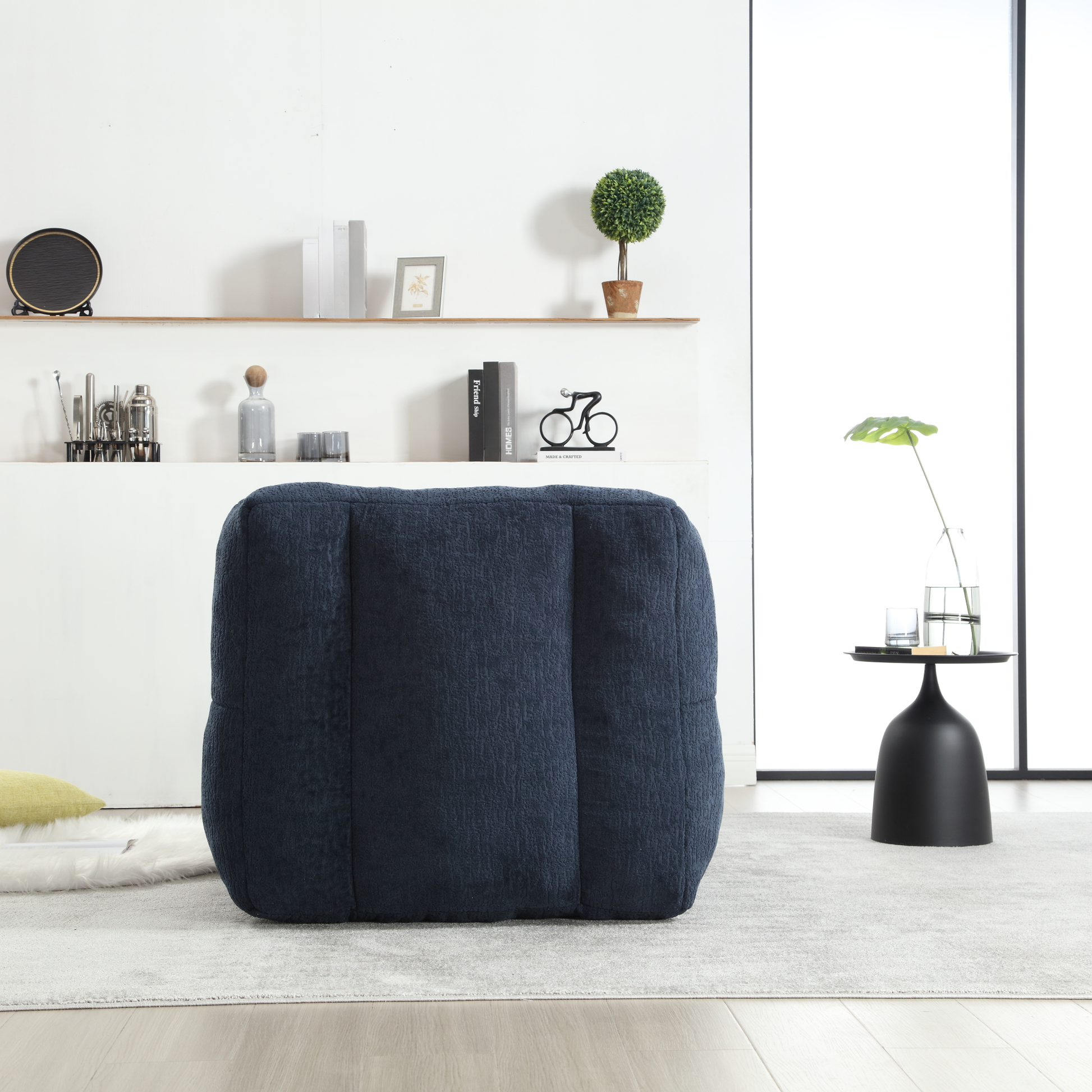 Navy blue textured fabric pouf ottoman with padded surface and stitched seams