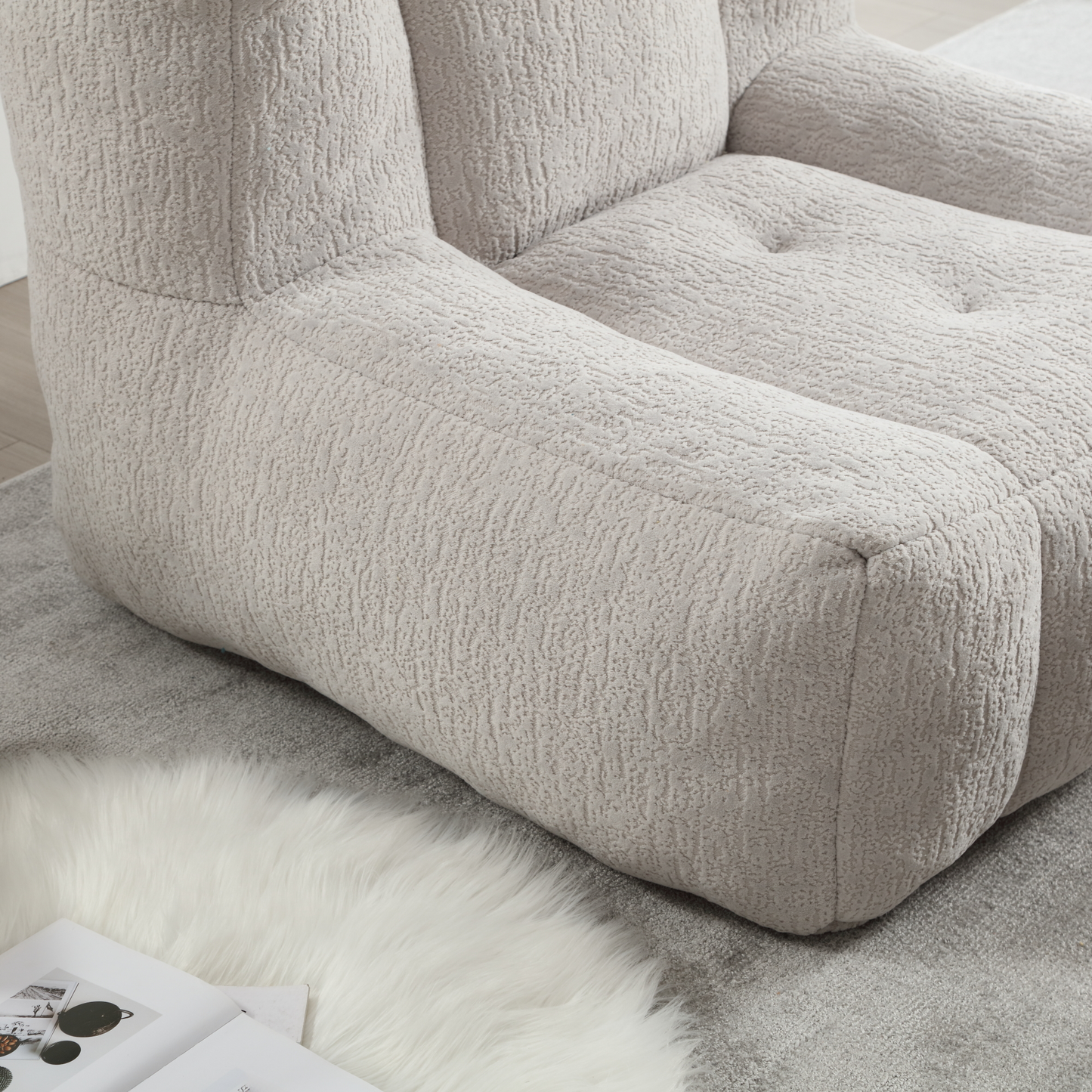 Plush cream boucle sofa armrest with tufted cushion detail for a cozy living room