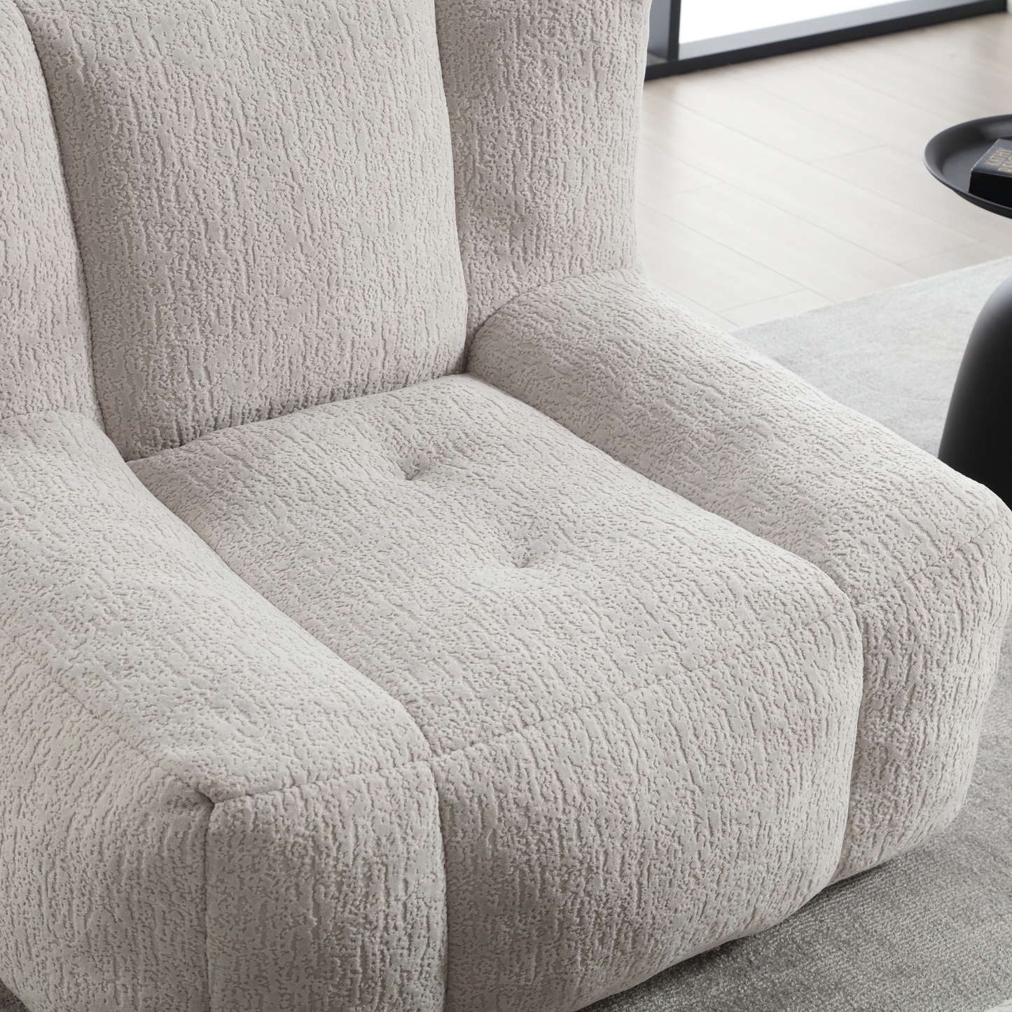 Closeup of a textured cream boucle armchairs seat and armrests offering cozy seating