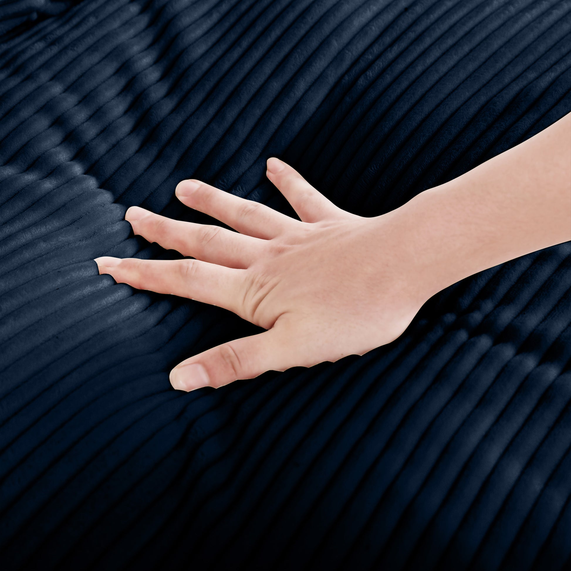 Closeup of hand touching plush navy blue corduroy fabric highlighting soft texture