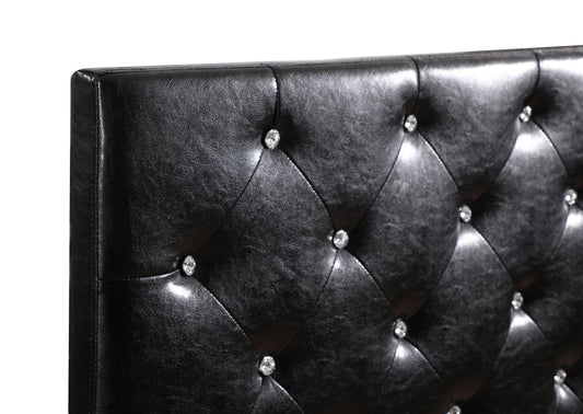 Closeup of a black faux leather tufted headboard with crystal accents