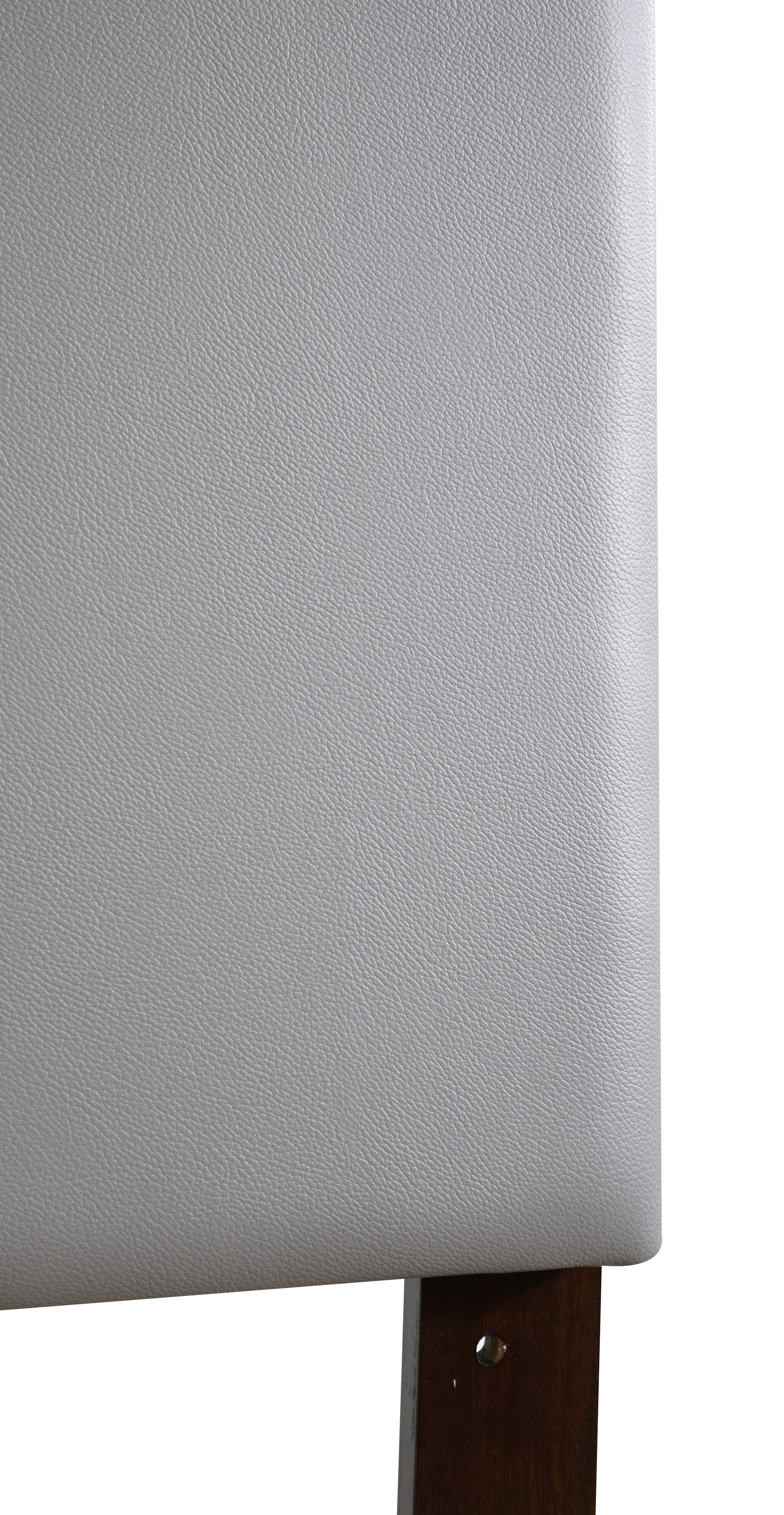 Closeup of a textured grey faux leather upholstered headboard with dark wood leg detail