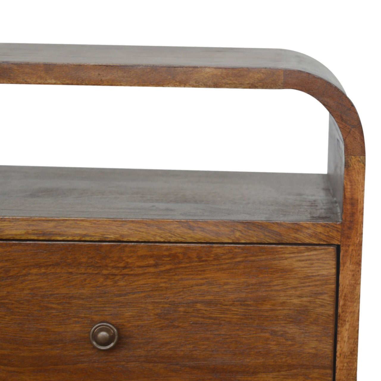 Closeup of a warm oak bedside table with curved edges and a single drawer