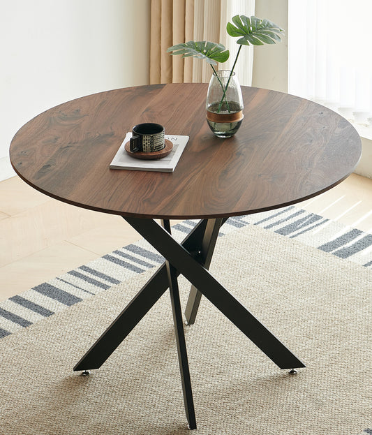 Round walnut dining table with black metal Xbase and decorative vase