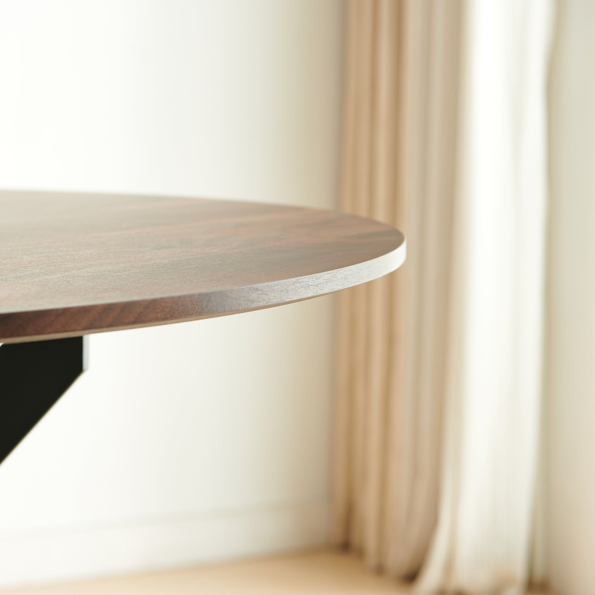 Dark walnut round dining table with clean lines and a modern design