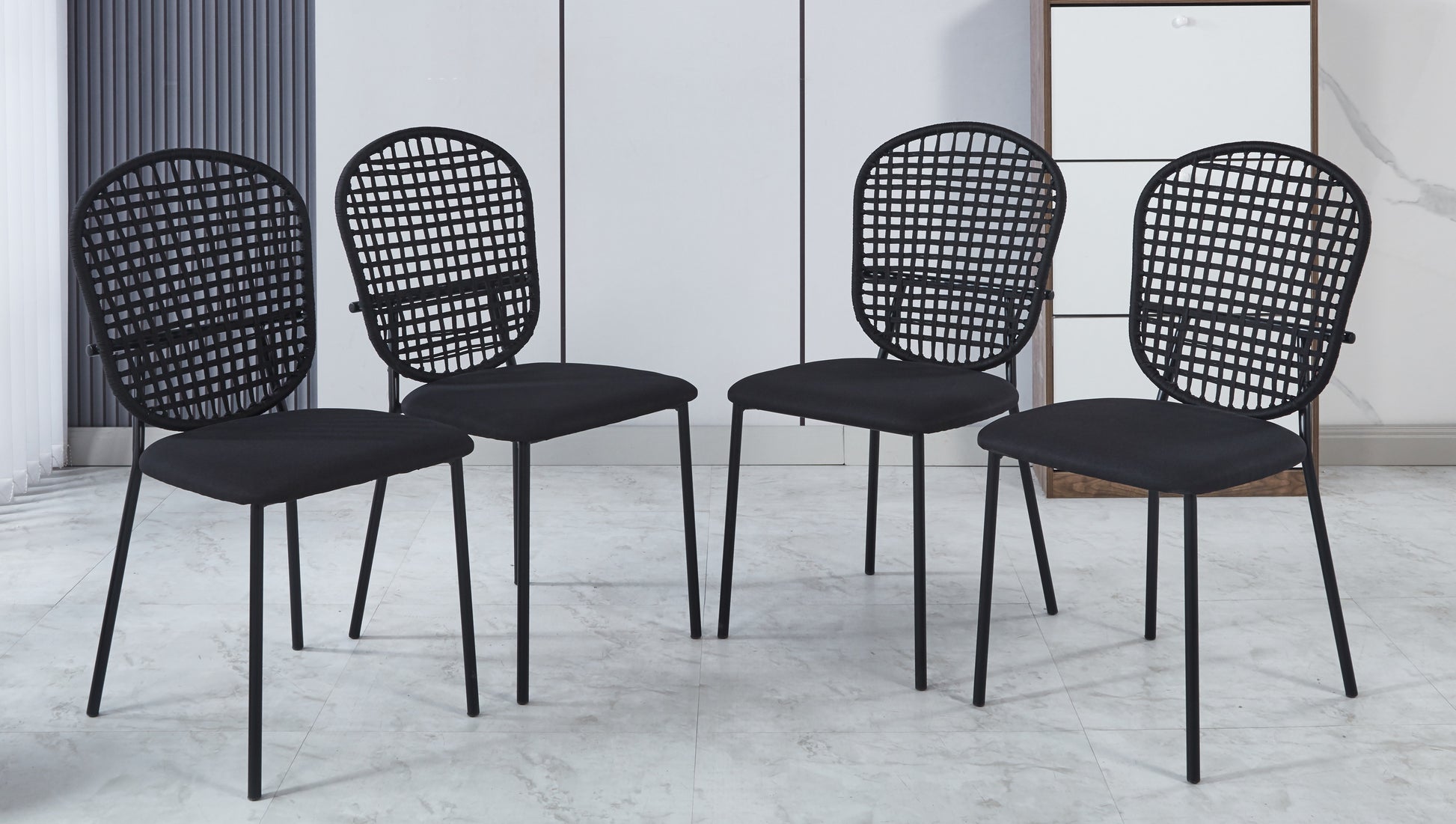 Four modern black dining chairs with woven backs and upholstered seats