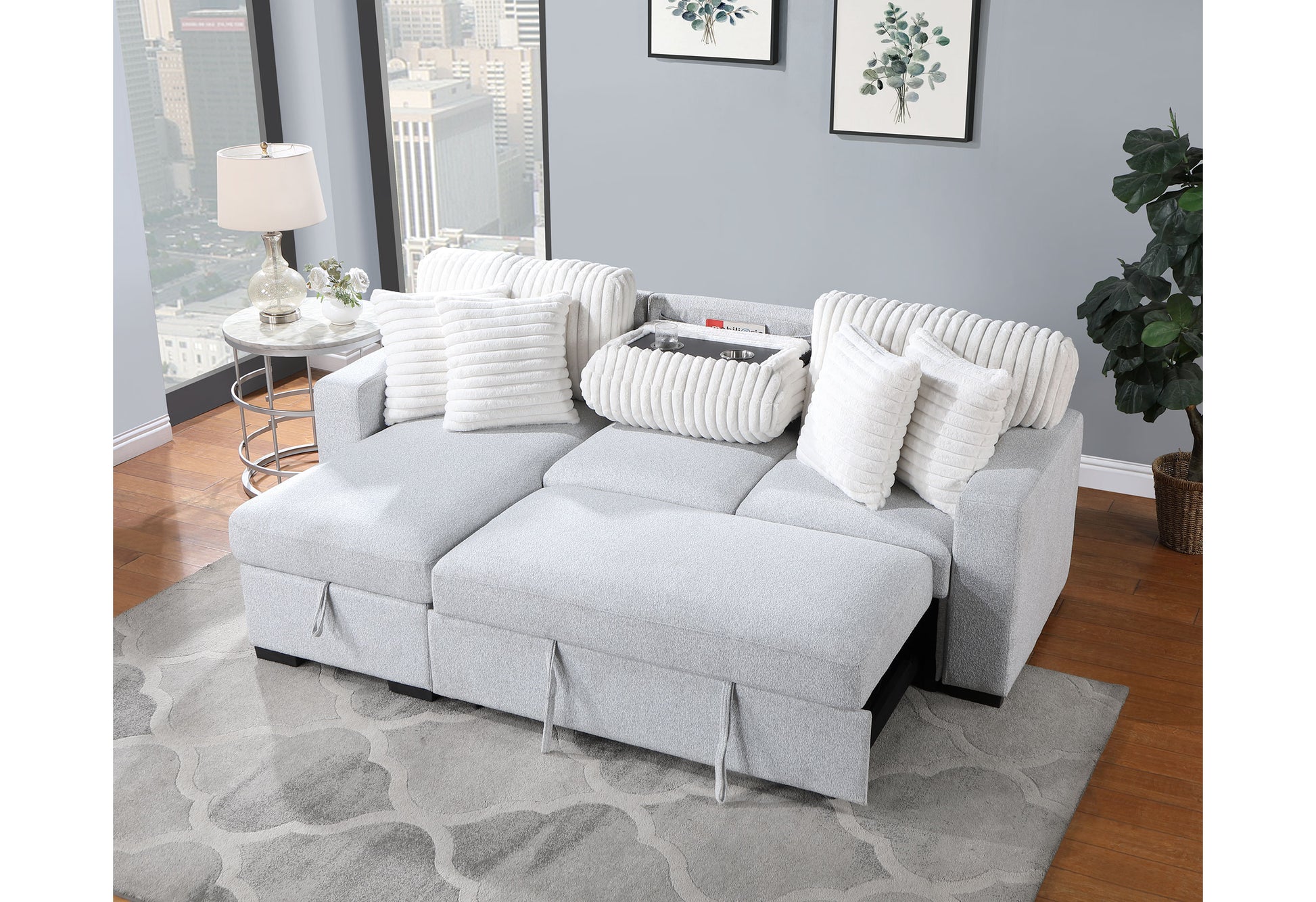 Light grey sectional sofa with pullout bed option and white plush pillows