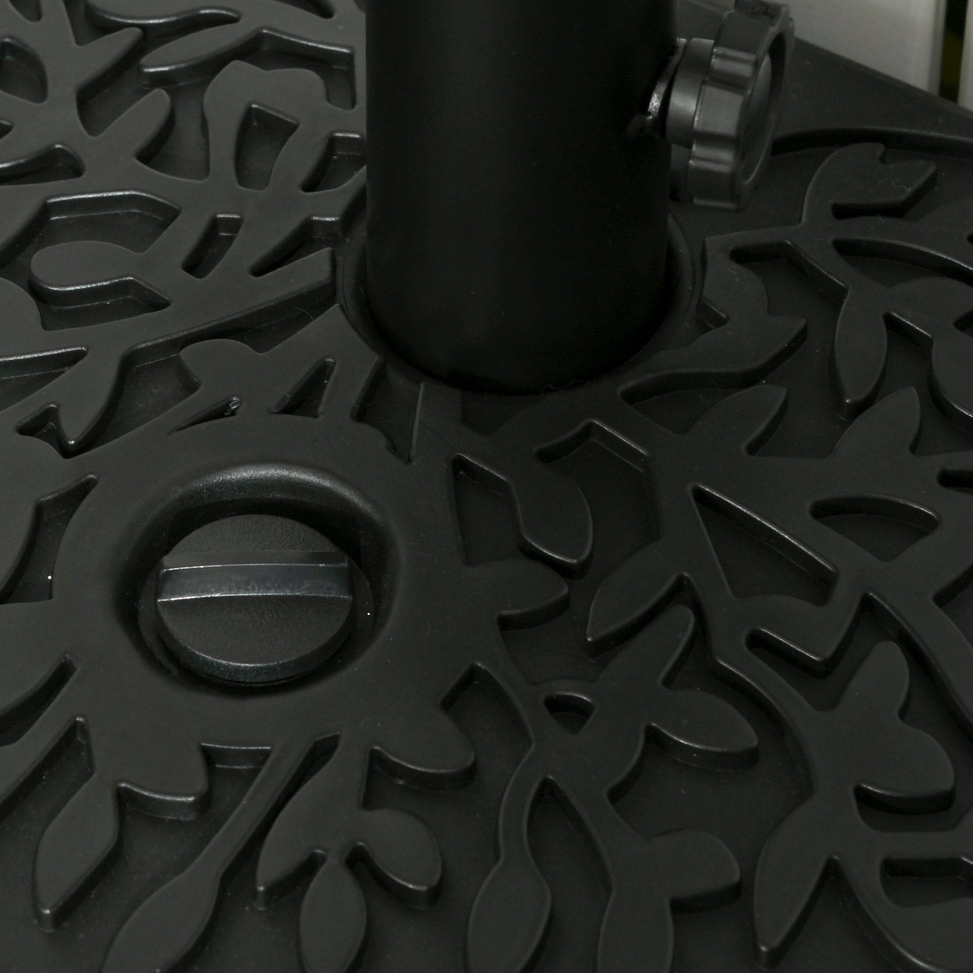 Closeup of a black decorative outdoor umbrella base with leaf pattern