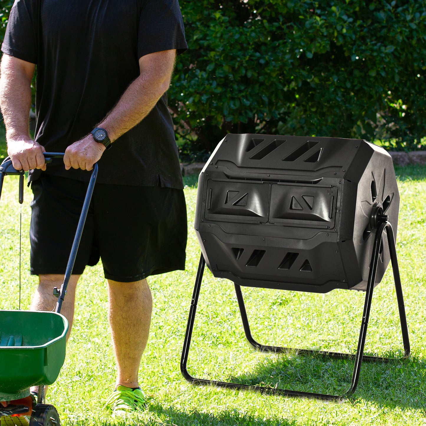 Black dualchamber tumbling composter with metal stand in sunny yard