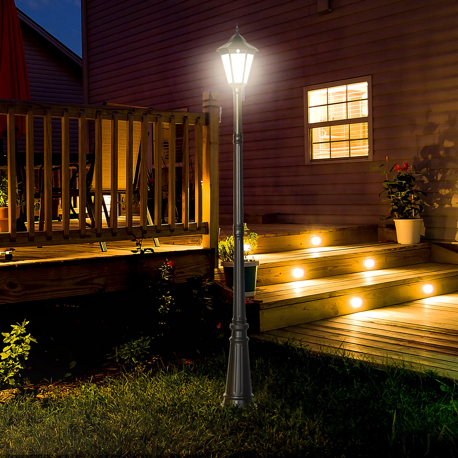 Classic black lamp post with vintage styling illuminates garden path at night