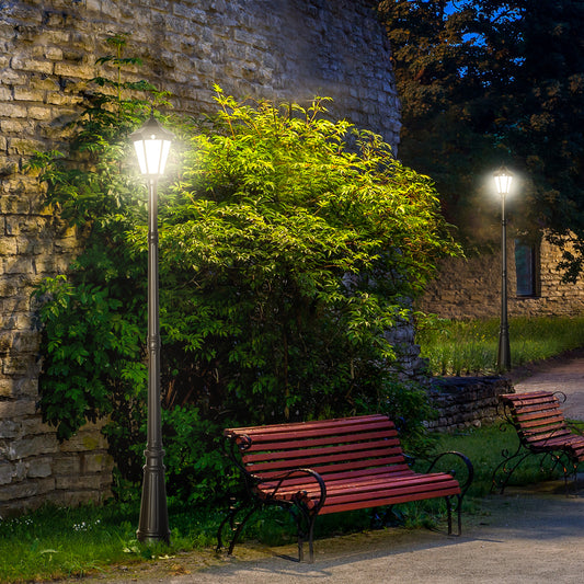 Classic black garden lamppost with lantern illuminating a park path at night