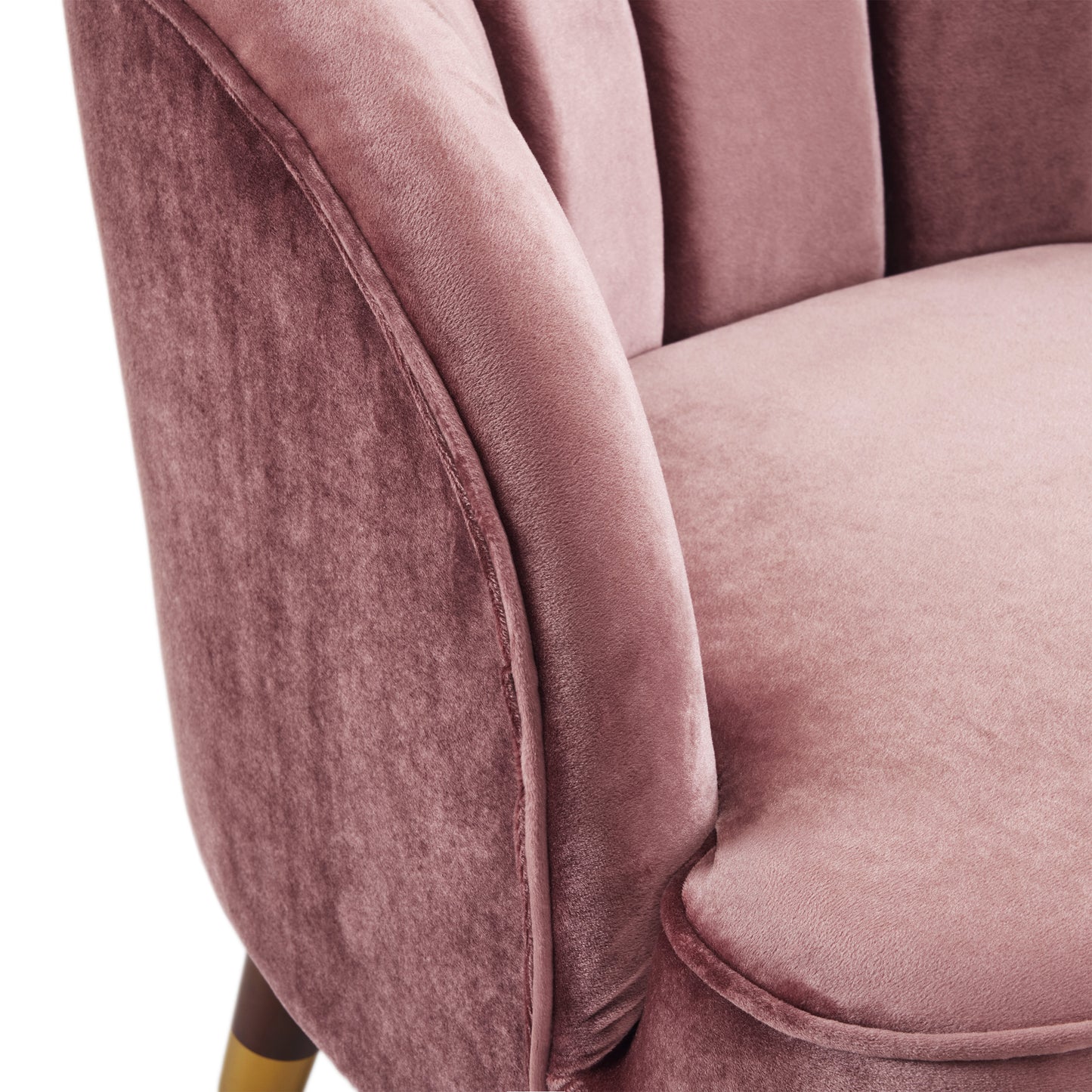 Closeup of a plush rose velvet armchair with channel tufting
