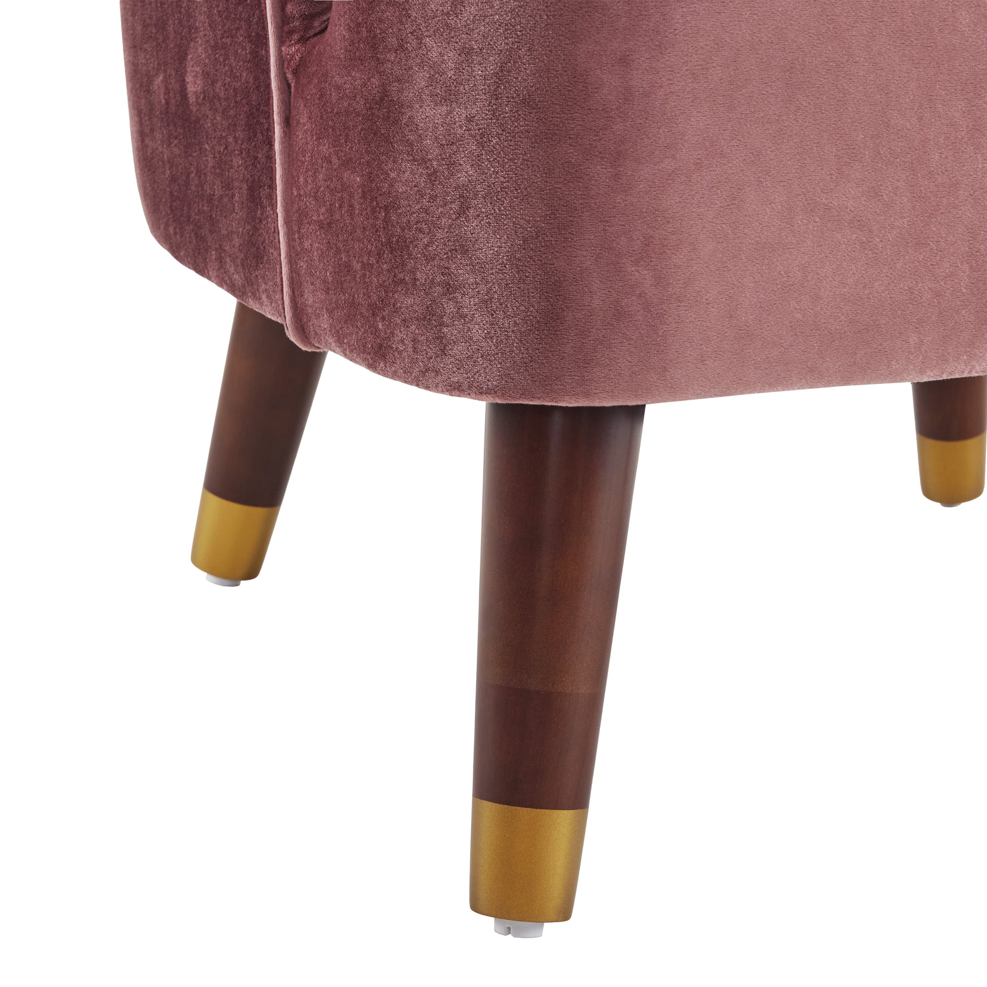 Rose velvet armchair detail with tapered wooden legs and gold accents