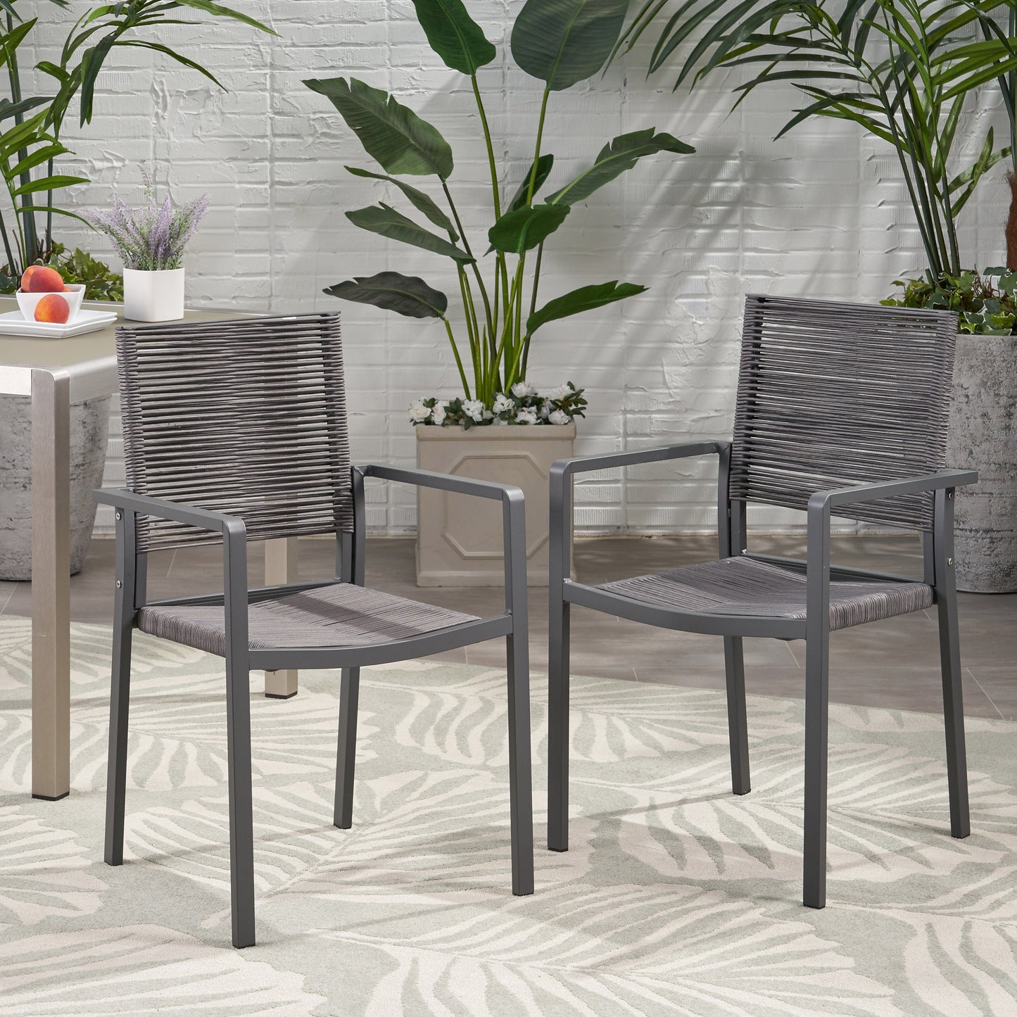 Two grey wicker outdoor chairs with metal frames offer a modern comfortable seating solution
