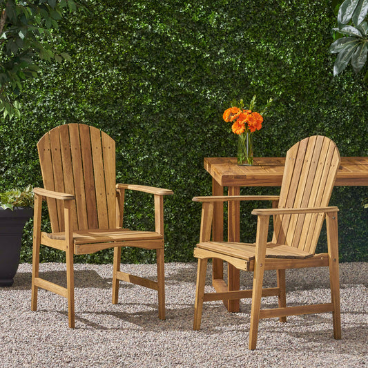 Two natural wood Adirondack chairs with slatted backs and seats arranged on gravel patio