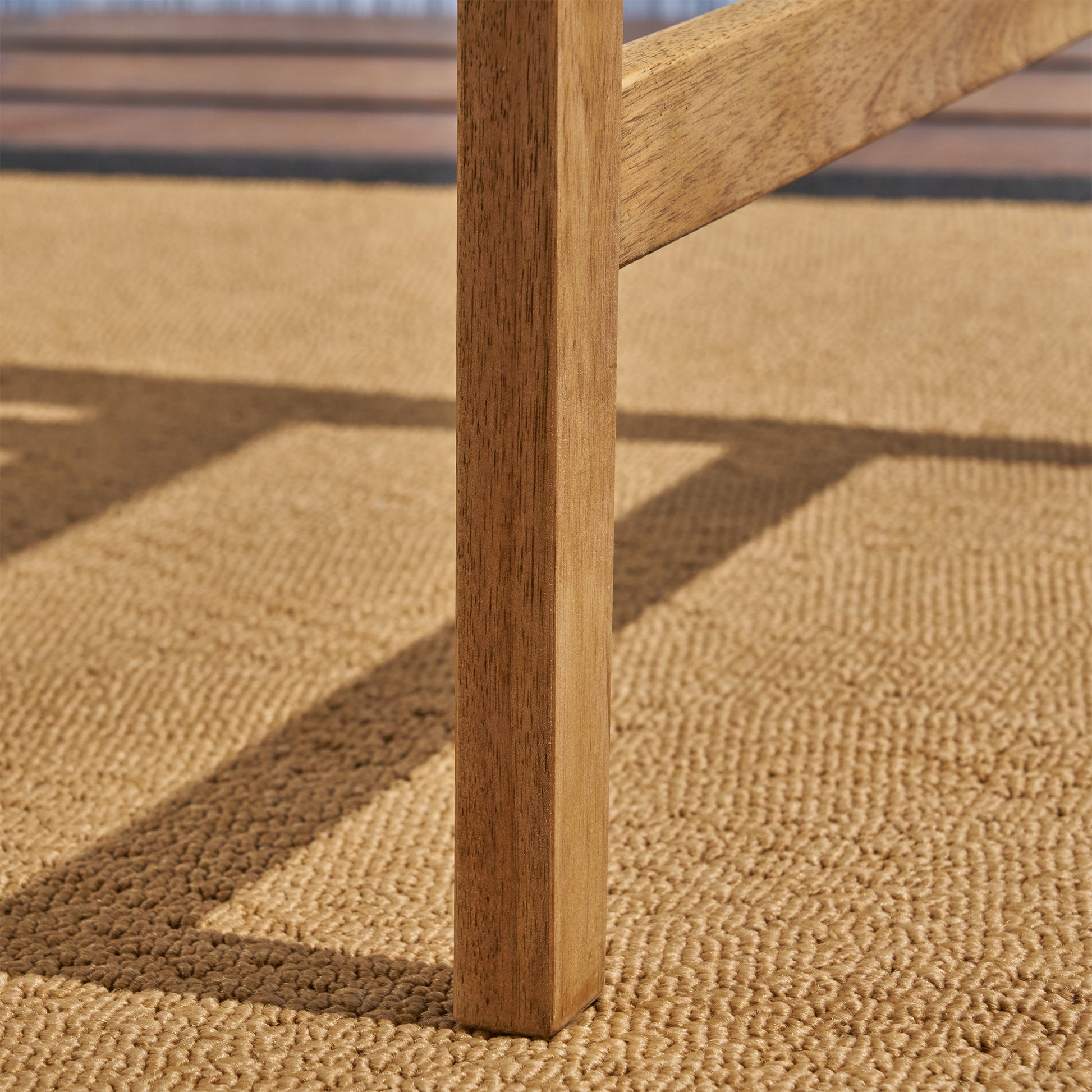 Solid wood table leg with natural grain texture on a jute rug