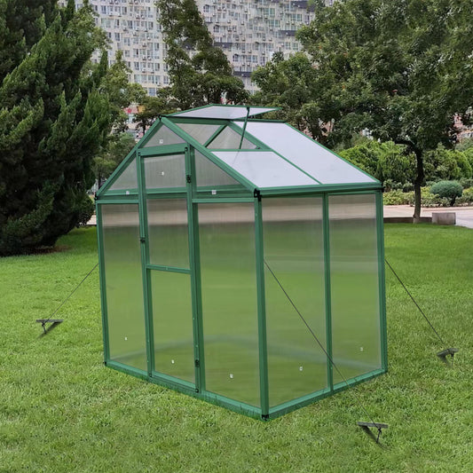 Green metal frame greenhouse with clear polycarbonate panels and a pitched roof