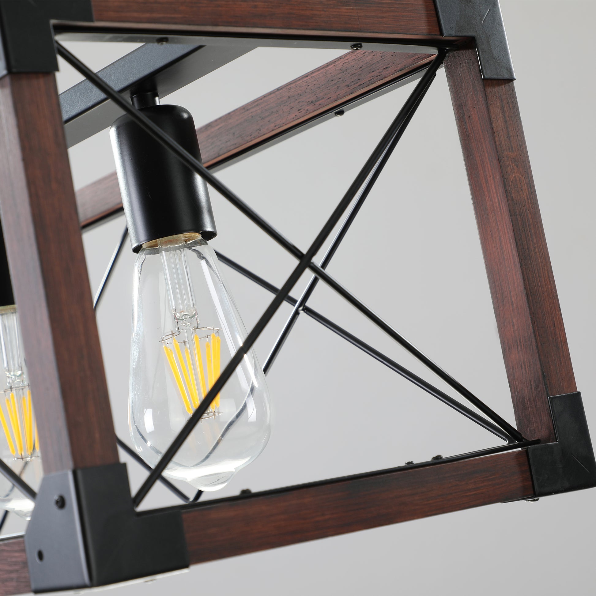 Closeup of industrial pendant light with dark wood frame and exposed Edison bulb