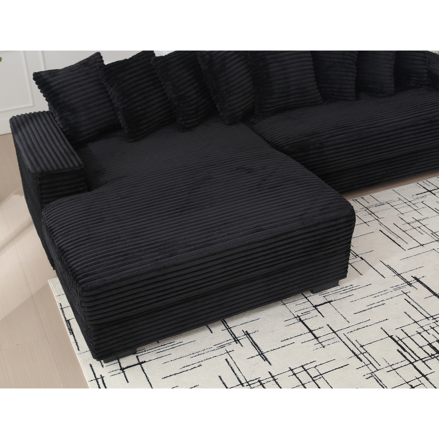 Black corduroy sectional sofa with plush throw pillows perfect for a modern living room