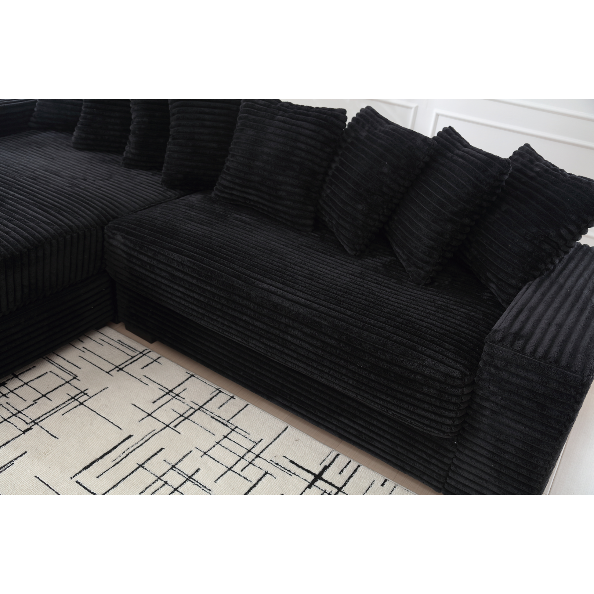 Plush black corduroy sectional sofa with textured cushions for a cozy living room