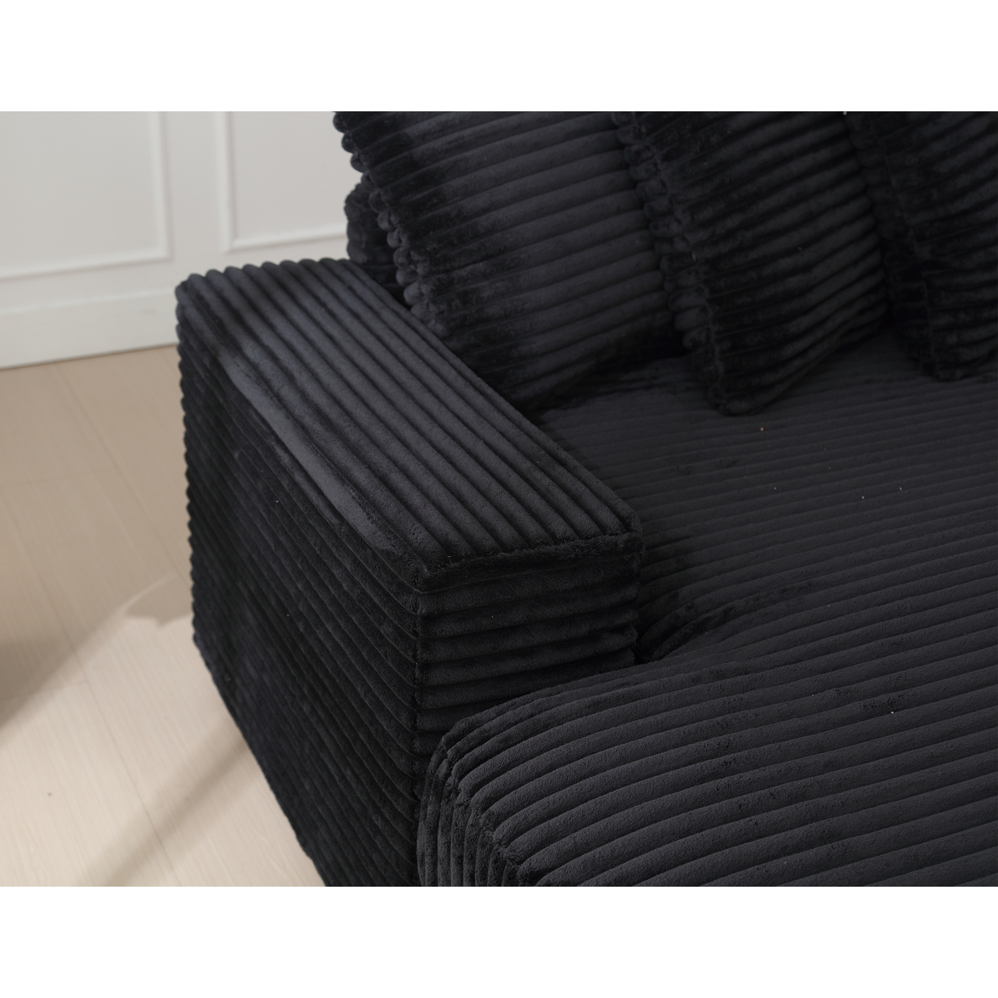 Black corduroy sofa armrest with plush cushions for comfort