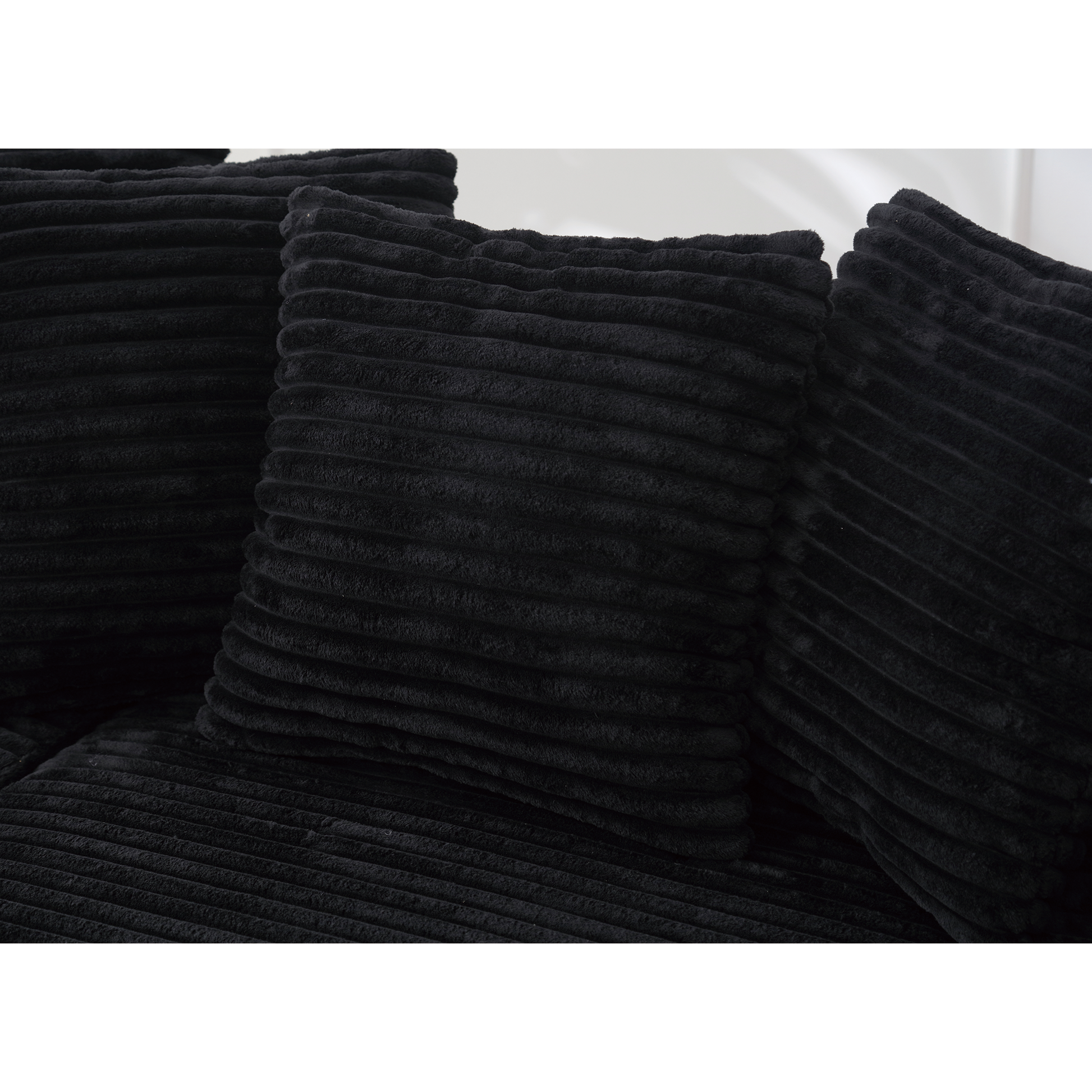 Black corduroy cushion with textured ribbed fabric adds cozy comfort