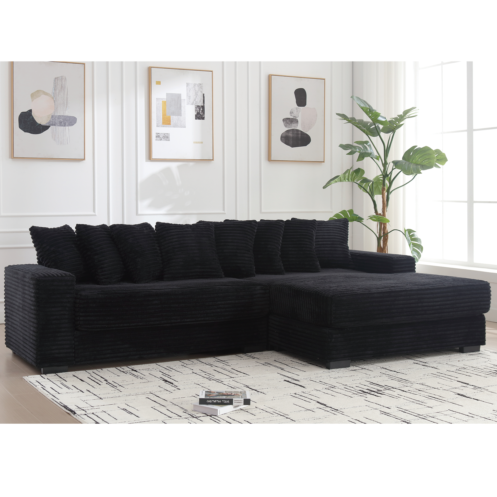 Black corduroy sectional sofa with plush cushions on a striped rug