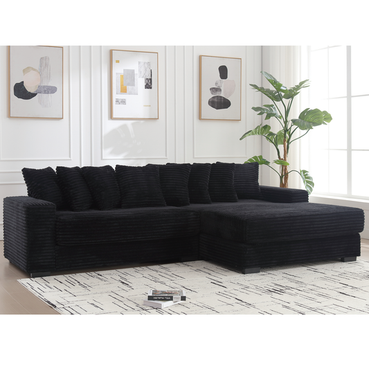 Black corduroy sectional sofa with plush cushions on a striped rug