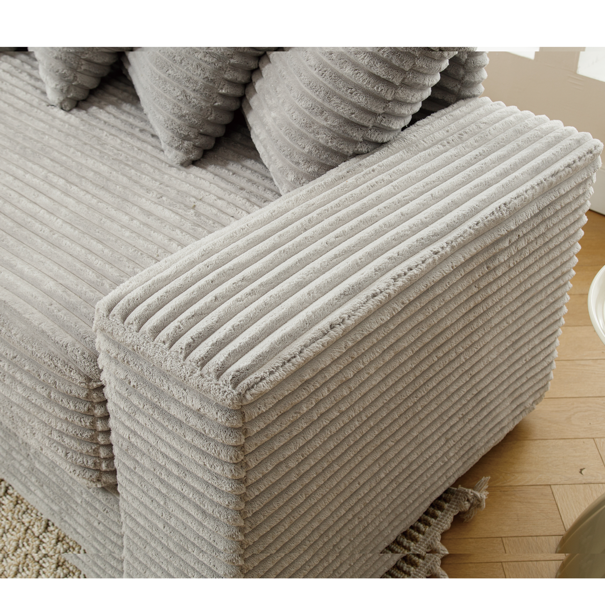 Closeup of a plush grey corduroy sofa section with visible texture and depth