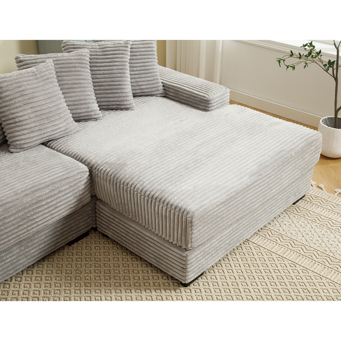 Light gray corduroy sectional sofa with plush throw pillows