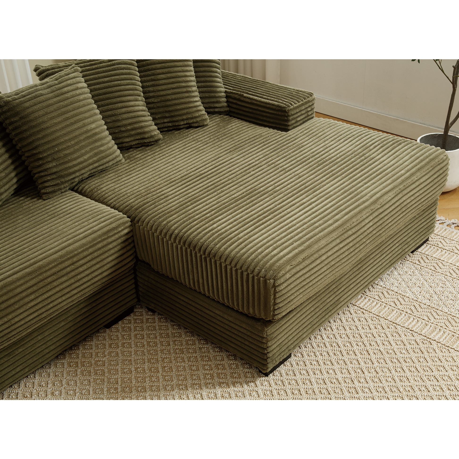 Green corduroy sectional sofa with plush throw pillows and chaise lounge