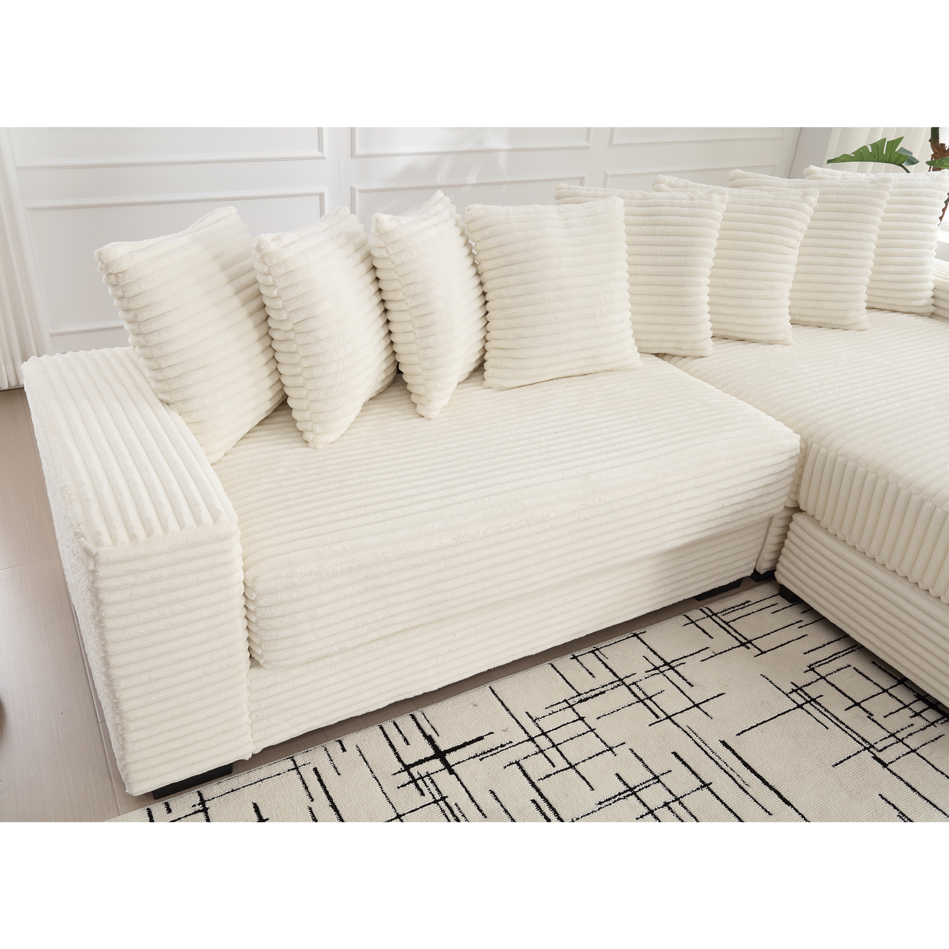 Cream corduroy sectional sofa with plush throw pillows and a modern rug
