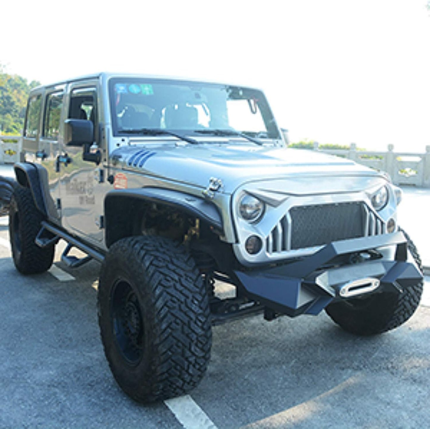 Silver Jeep Wrangler with aggressive front bumper and winch