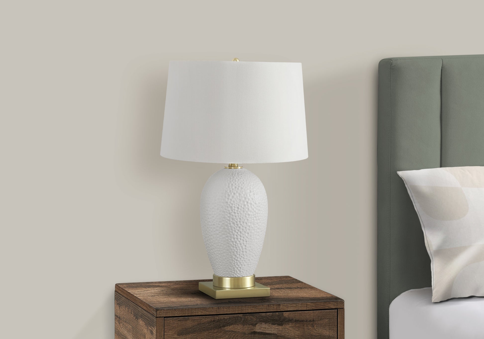 White textured ceramic table lamp with a white linen drum shade and brass base
