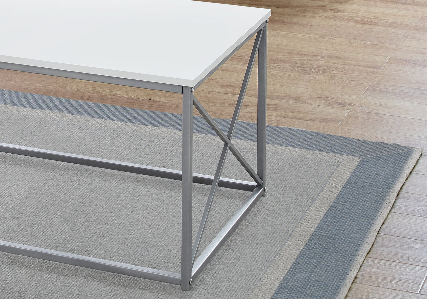 Modern white coffee table with grey metal frame on a rug