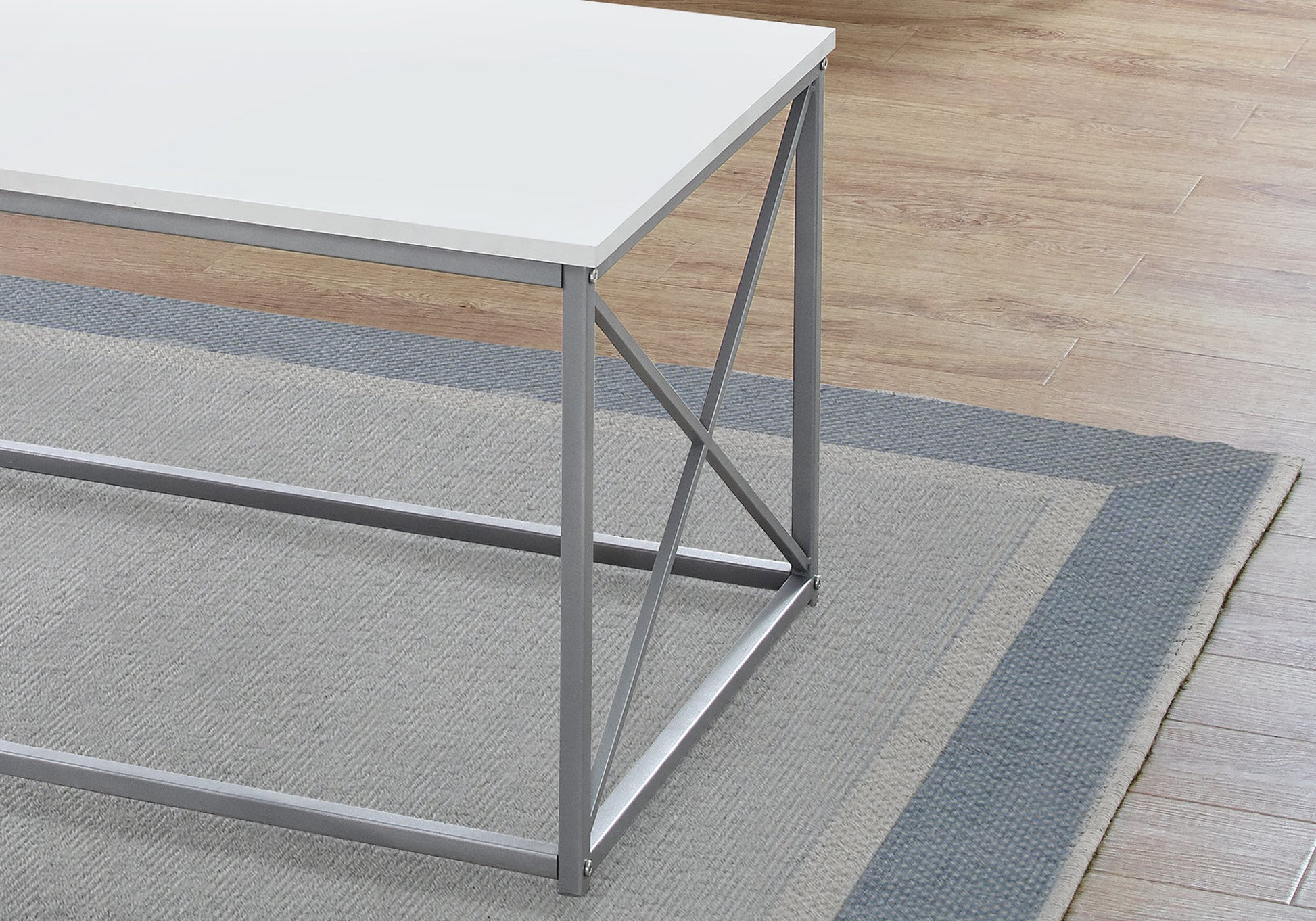 Modern white coffee table with grey metal frame on a rug