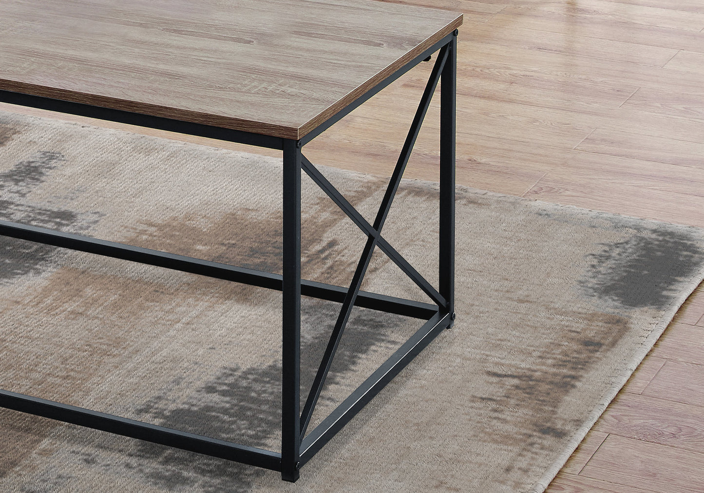 Modern coffee table with rustic wood grain top and black metal Xframe legs on a textured rug