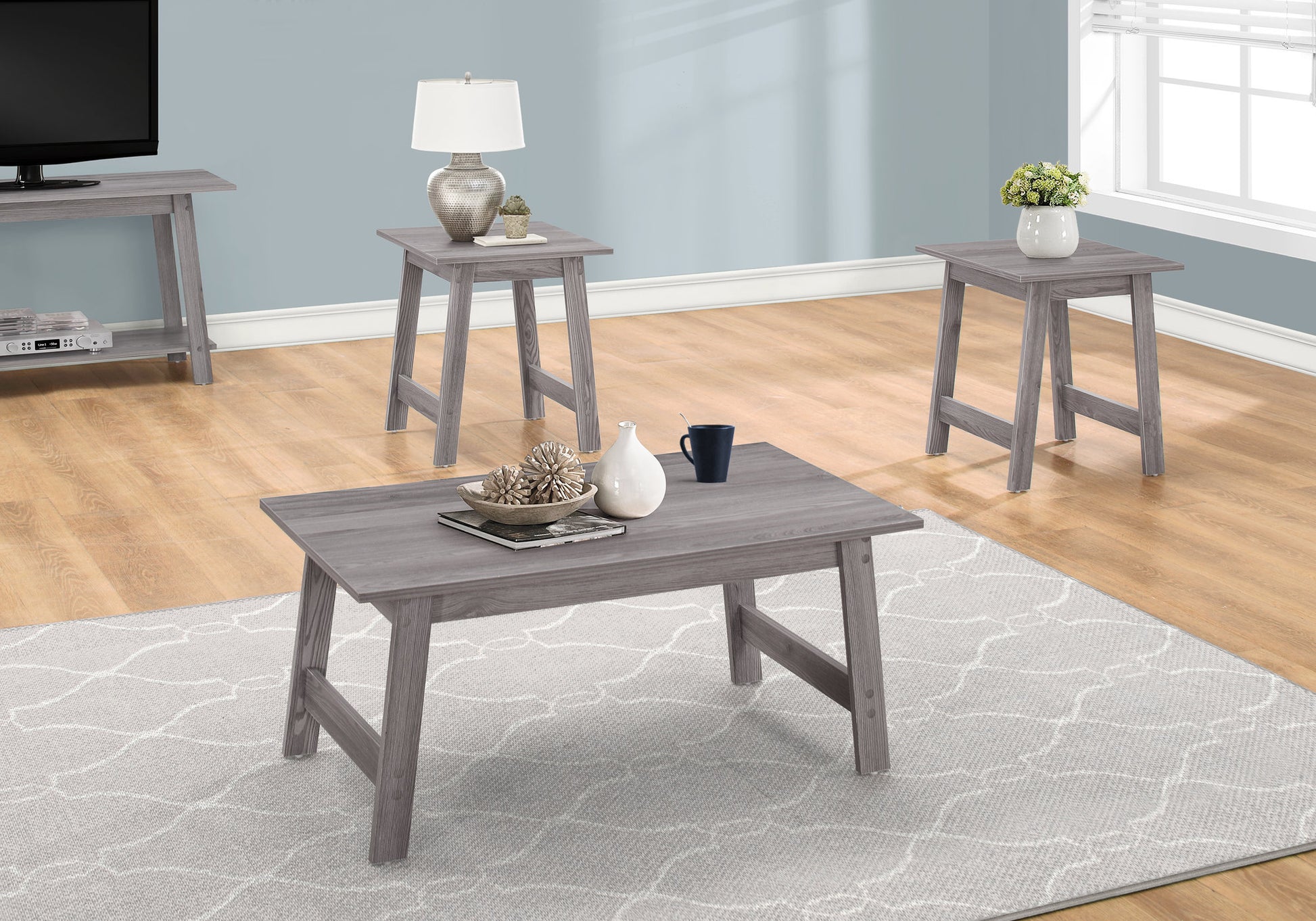 Grey modern coffee table with textured decor white vase and dark blue mug on a patterned rug