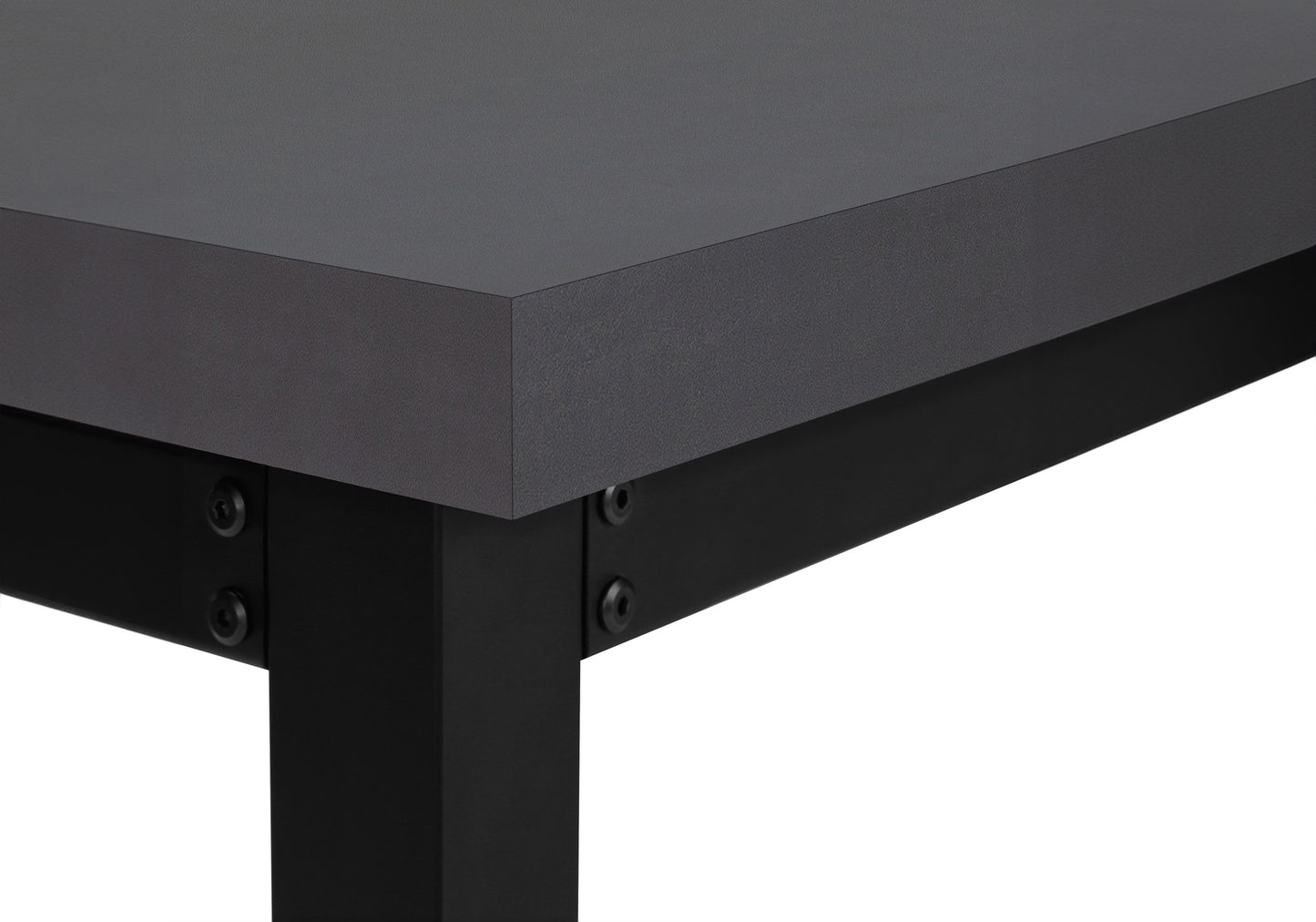 Closeup of a dark grey laminate desk edge with black metal legs and visible screws