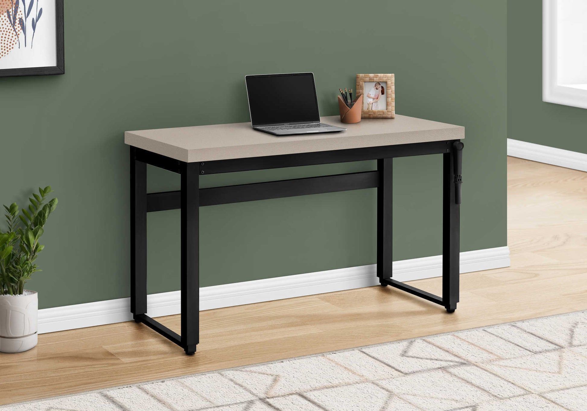 Modern taupe computer desk with black metal legs featuring a laptop and photo frame