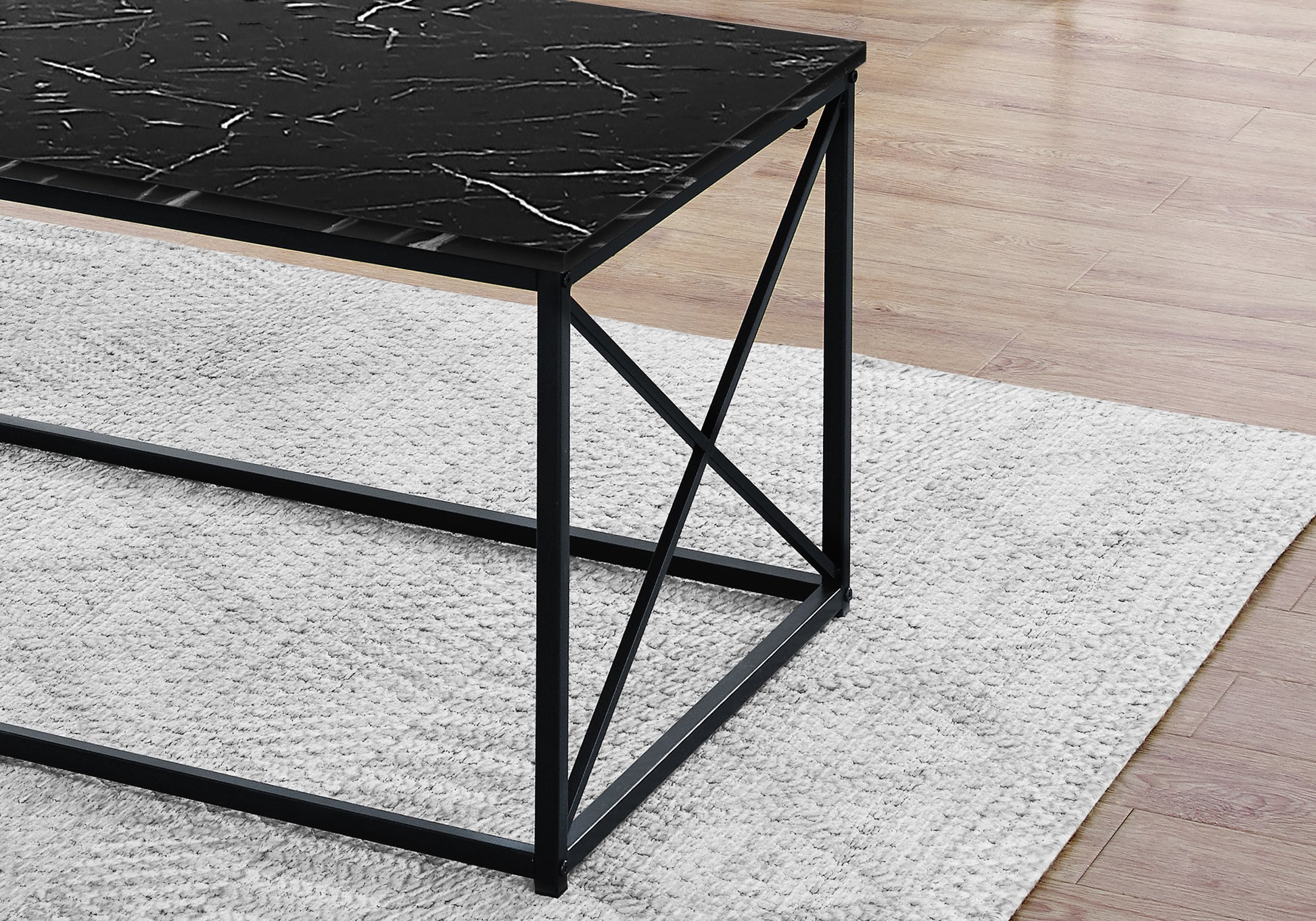 Black marble top coffee table with modern black metal frame on shaggy rug