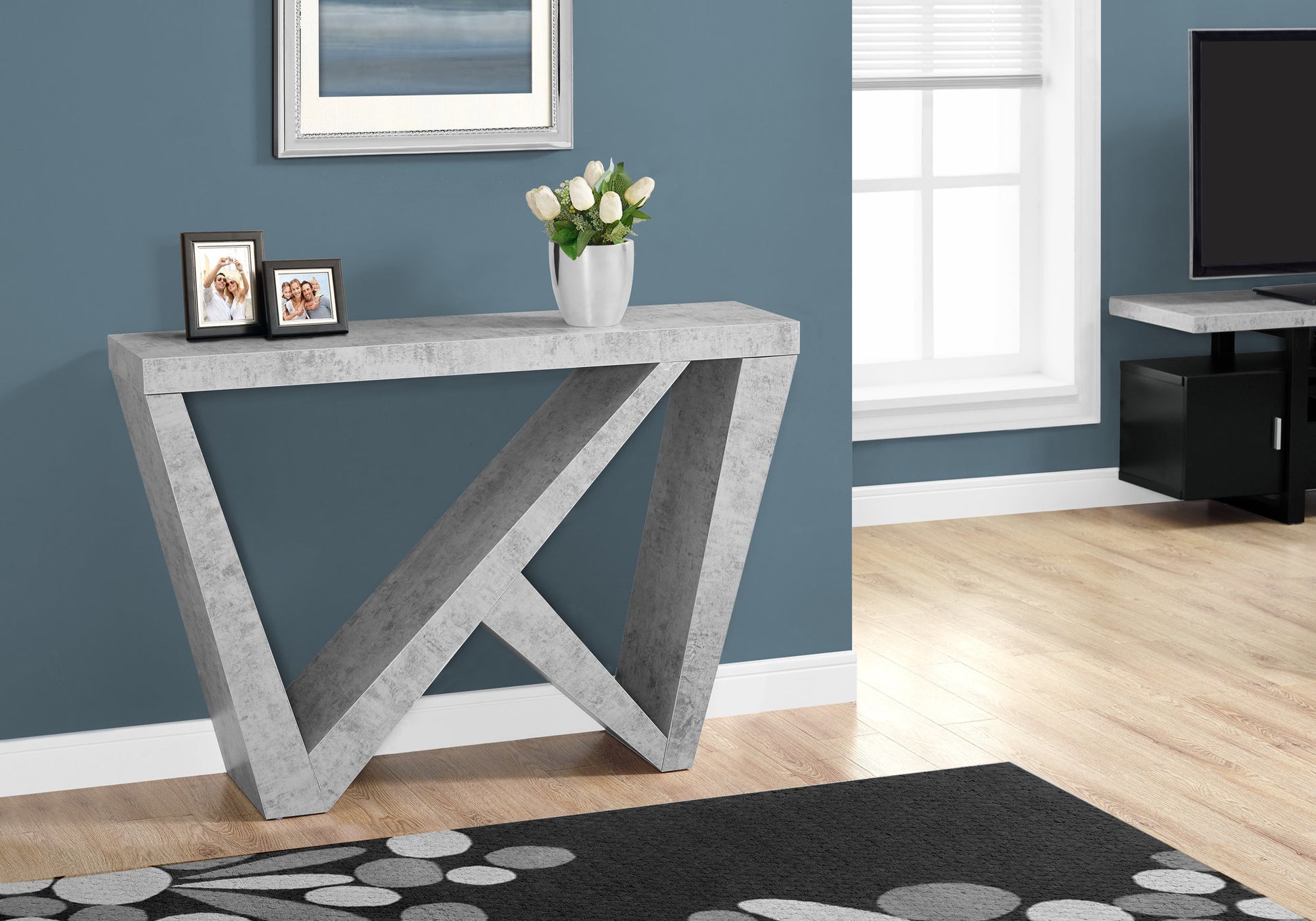 Modern gray concrete console table with geometric legs and a faux marble top