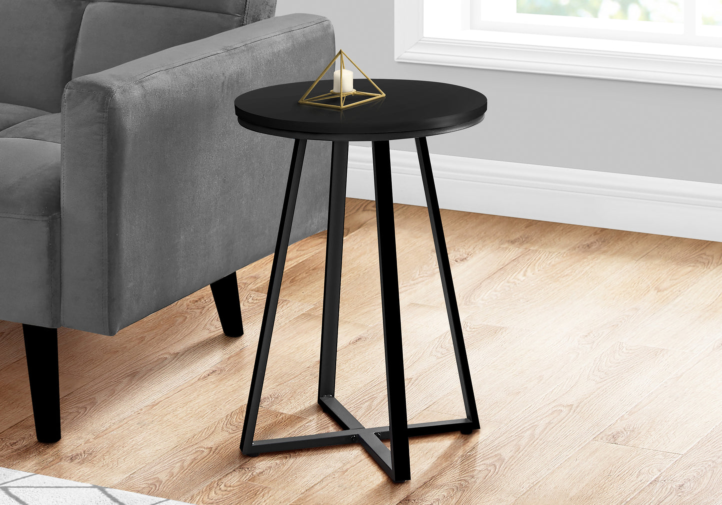 Modern black round end table with a geometric gold candle holder