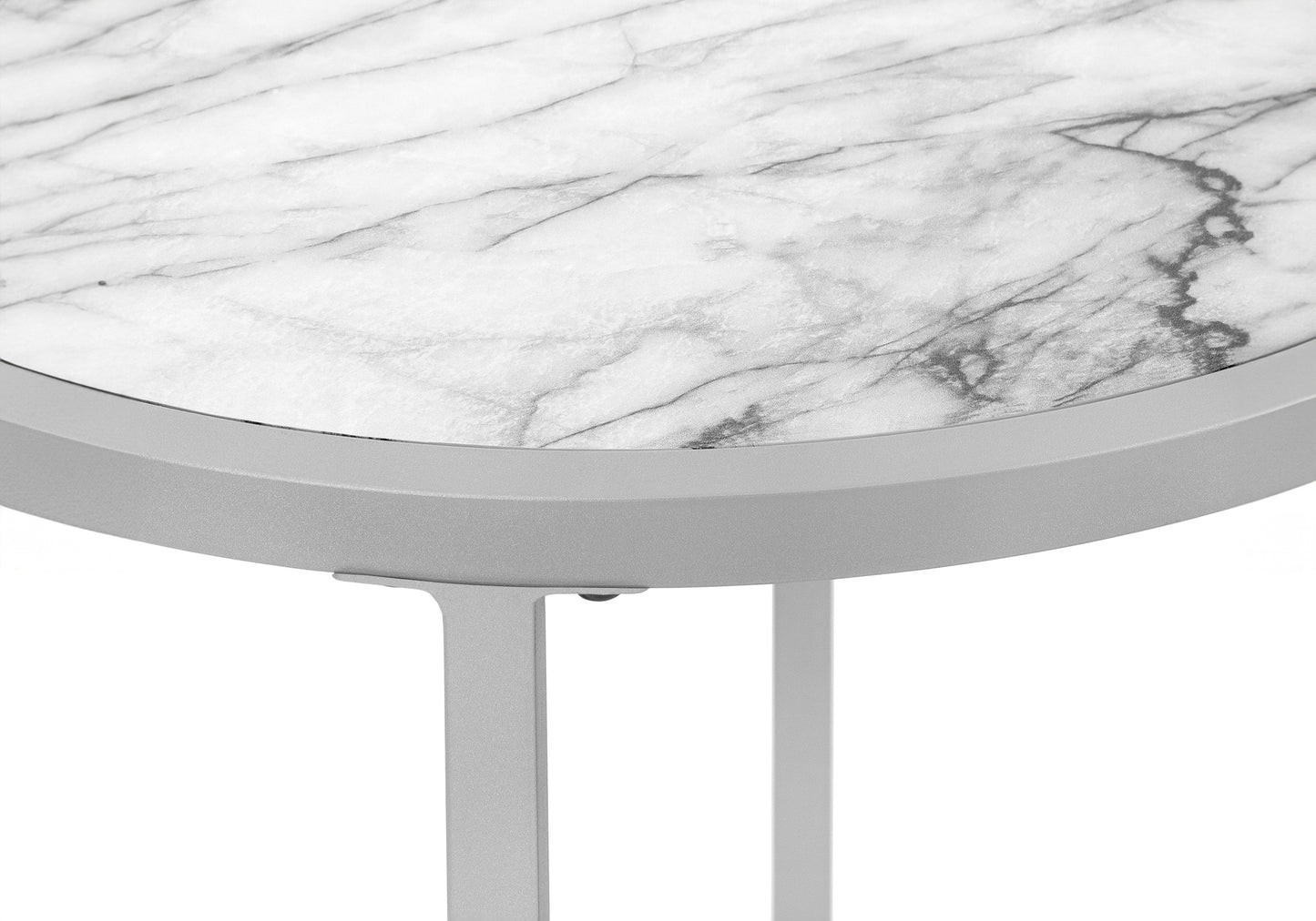Closeup of a round side table with a white marble top and silver metal frame