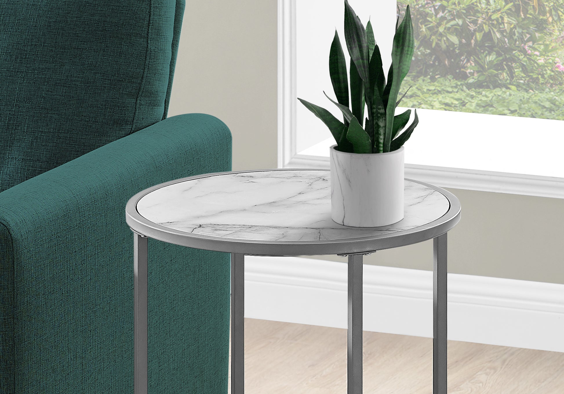 Marbletop end table with silver metal frame next to teal armchair