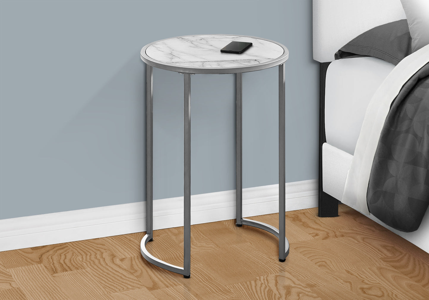Round end table with marble top and chrome base featuring a phone