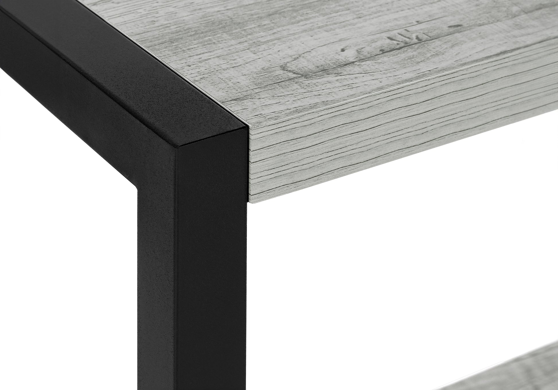 Closeup of a light grey wood grain tabletop with a textured black metal frame edge