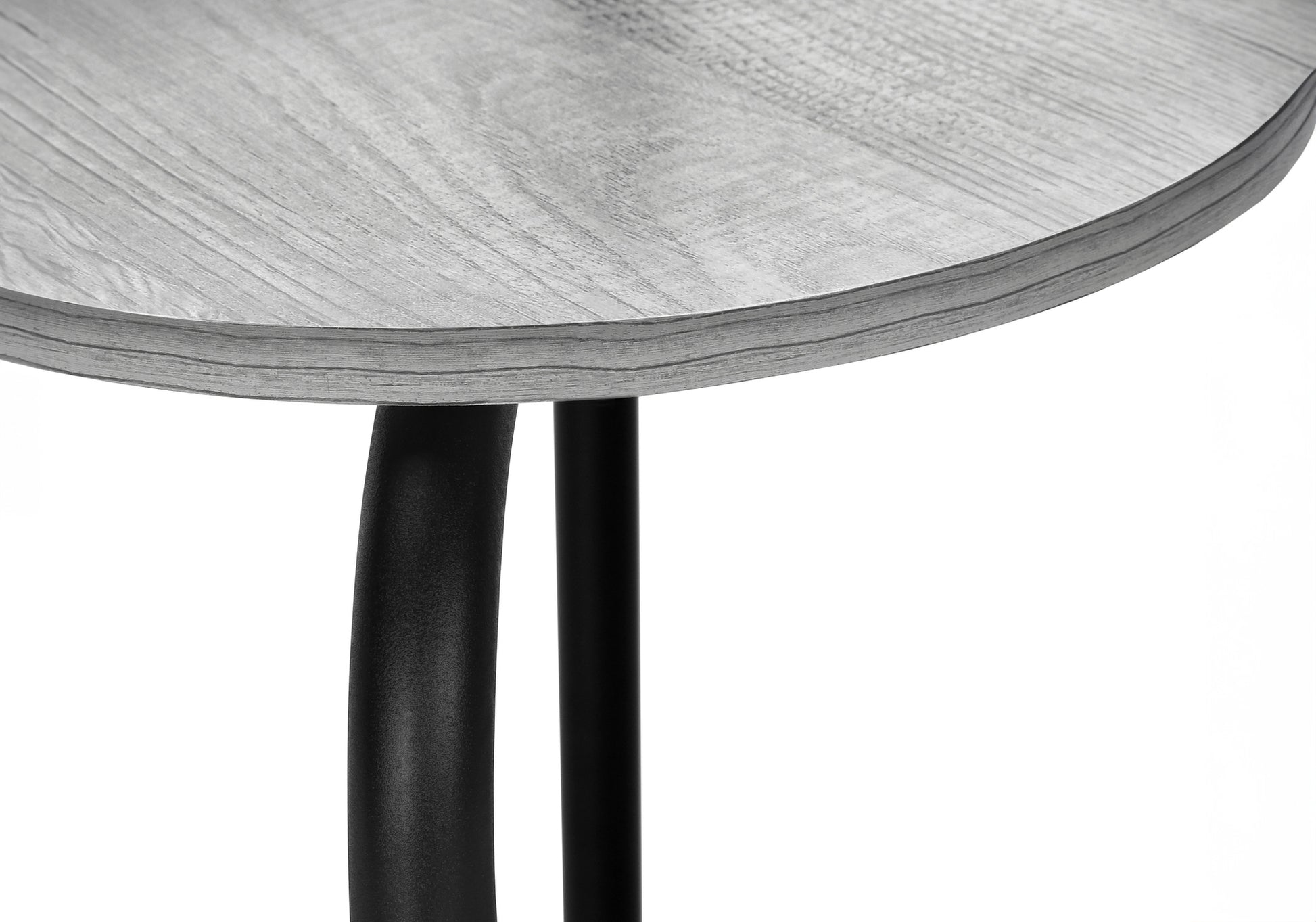 Closeup of a round grey wood grain side table top with black metal legs