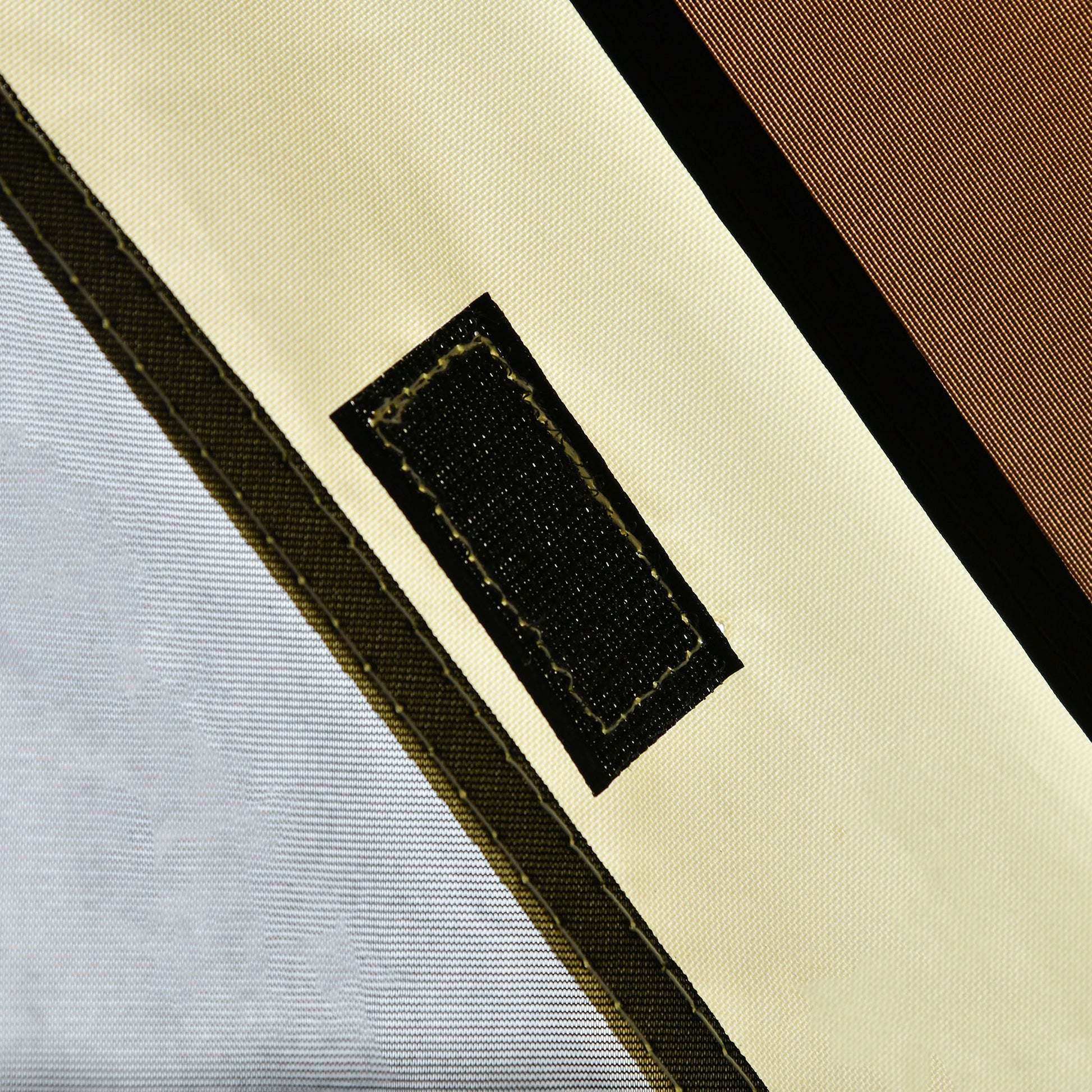 Closeup of creamcolored canvas fabric with black velcro closure ideal for outdoor gear